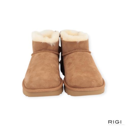 Ugg Ultra Mini Bailey Bow enkellaars in cognac, chestnut suède met wol en strik voor dames. Ugg Ultra Mini Bailey Bow enkellaars in cognac, chestnut suède met wol en strik voor dames.