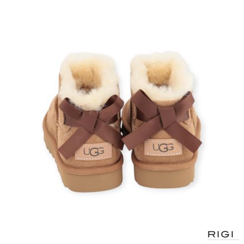 Ugg Ultra Mini Bailey Bow enkellaars in cognac, chestnut suède met wol en strik voor dames. Ugg Ultra Mini Bailey Bow enkellaars in cognac, chestnut suède met wol en strik voor dames.