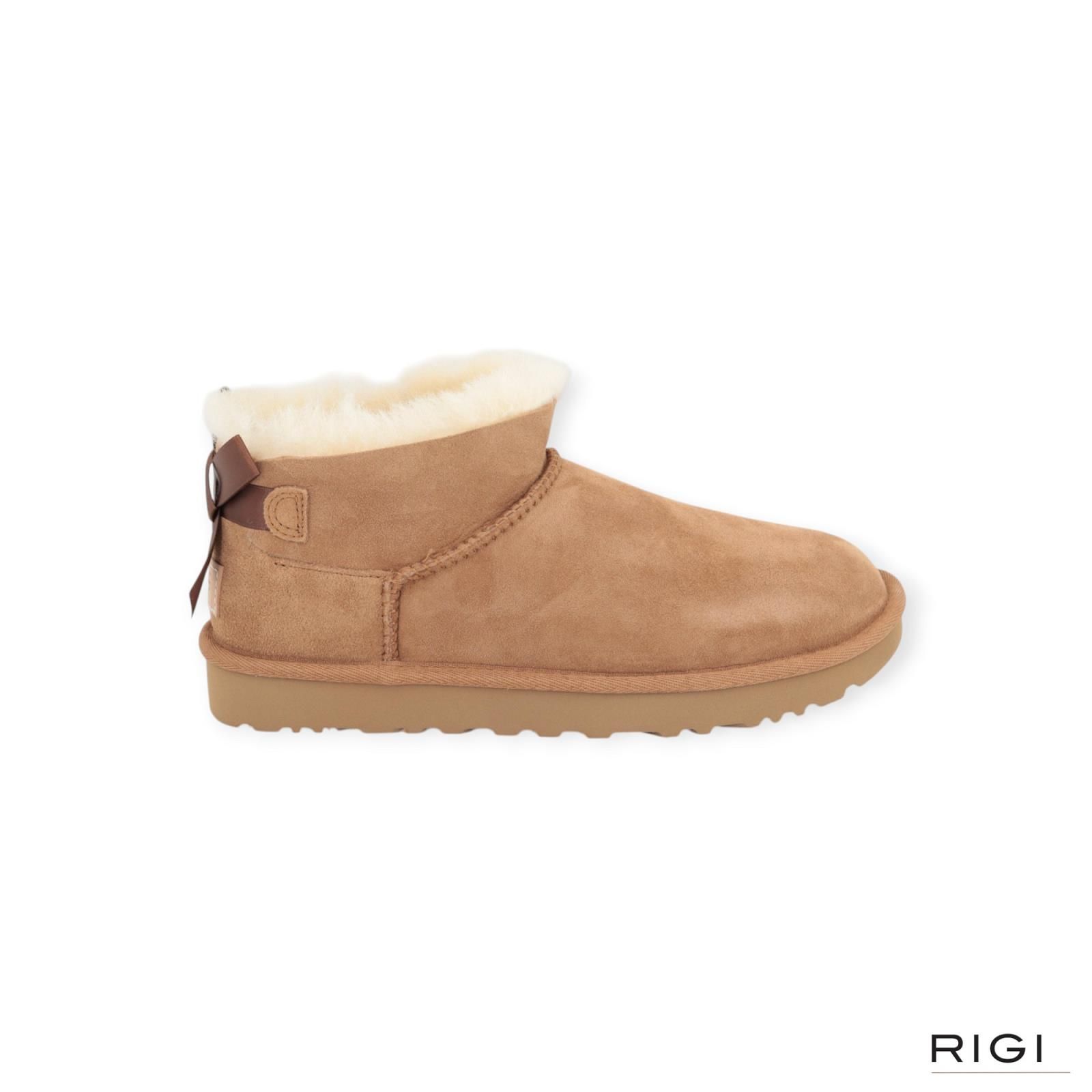 Ugg Ultra Mini Bailey Bow enkellaars in cognac, chestnut suède met wol en strik voor dames. Ugg Ultra Mini Bailey Bow enkellaars in cognac, chestnut suède met wol en strik voor dames.